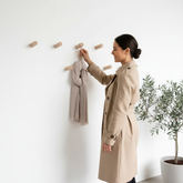 femme accrochant echarppe sur patere