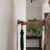 femme accrochant parapluie sur patere